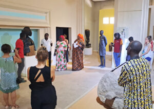 Les participants à l'atelier-laboratoire debouts devant une statue dans une salle du musée